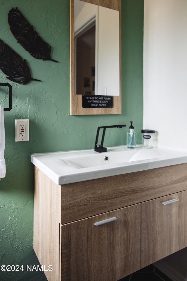 bathroom featuring a textured wall and vanity