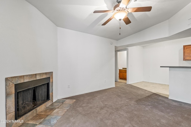 unfurnished living room featuring a fireplace, carpet floors, lofted ceiling, and ceiling fan