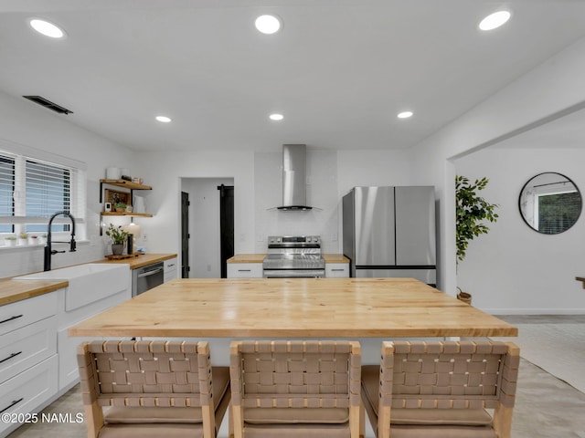 389 N Laramy Ln, Parks, AZ 86018 - kitchen with butcher block counters, wall chimney range hood, stainless steel appliances, a sink, and open shelves
