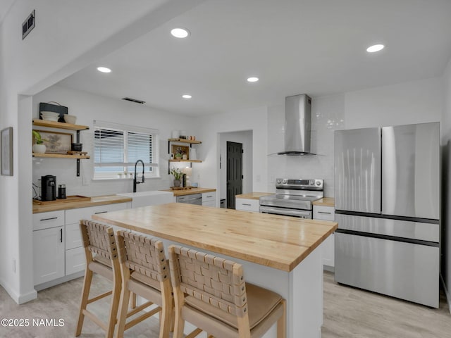 389 N Laramy Ln, Parks, AZ 86018 - kitchen with butcher block countertops, stainless steel appliances, wall chimney range hood, open shelves, and recessed lighting
