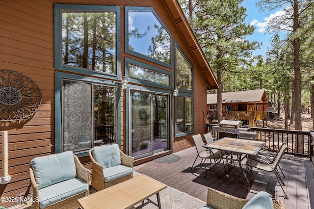 deck featuring outdoor dining space and a grill