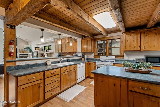 kitchen with a sink, wooden ceiling, beamed ceiling, a peninsula, and white appliances