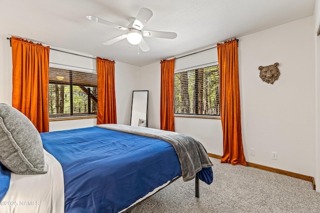 carpeted bedroom with baseboards, multiple windows, and ceiling fan