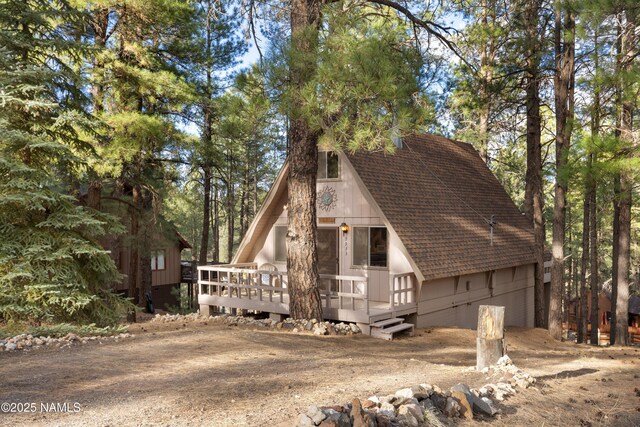 a-frame home with a wooden deck and a shingled roof