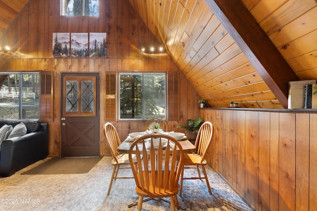 carpeted dining space with lofted ceiling, wooden walls, wood ceiling, and a healthy amount of sunlight