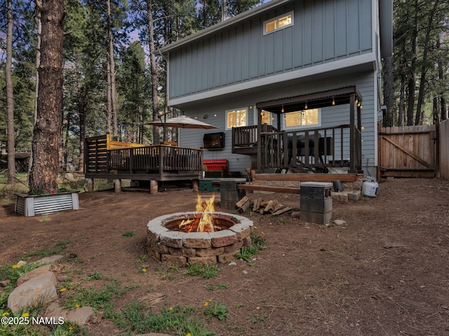 867 Onieda, Flagstaff, AZ 86005 - rear view of property featuring board and batten siding, a fire pit, a wooden deck, a gate, and fence