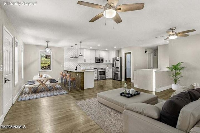 4573 Canyon Loop, Flagstaff, AZ 86005 - living room featuring a ceiling fan, a textured ceiling, dark wood-style floors, baseboards, and recessed lighting