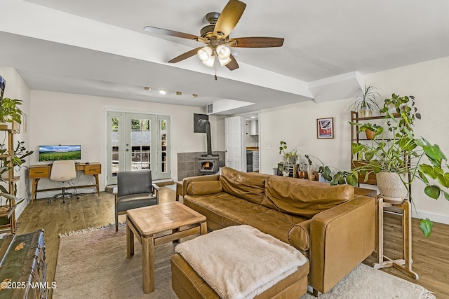 4573 Canyon Loop, Flagstaff, AZ 86005 - living area with a wood stove, wood finished floors, ceiling fan, and french doors