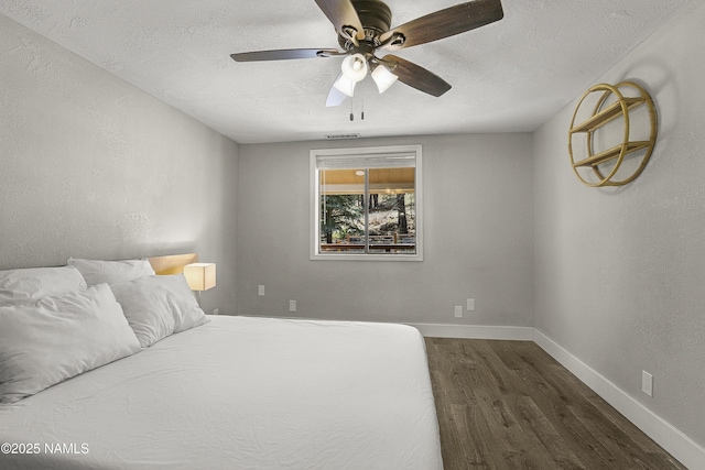 4573 Canyon Loop, Flagstaff, AZ 86005 - bedroom featuring dark wood-style floors, a textured ceiling, a ceiling fan, and baseboards