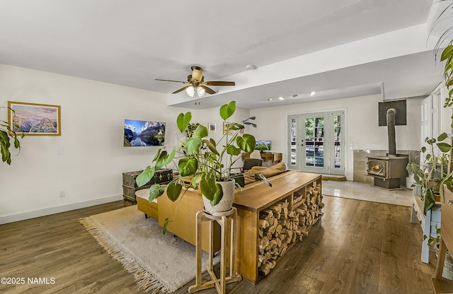 4573 Canyon Loop, Flagstaff, AZ 86005 - living room with wood finished floors, a wood stove, french doors, ceiling fan, and baseboards