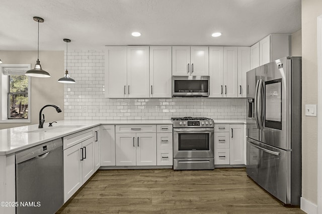 4573 Canyon Loop, Flagstaff, AZ 86005 - kitchen featuring appliances with stainless steel finishes, a sink, a peninsula, light countertops, and recessed lighting