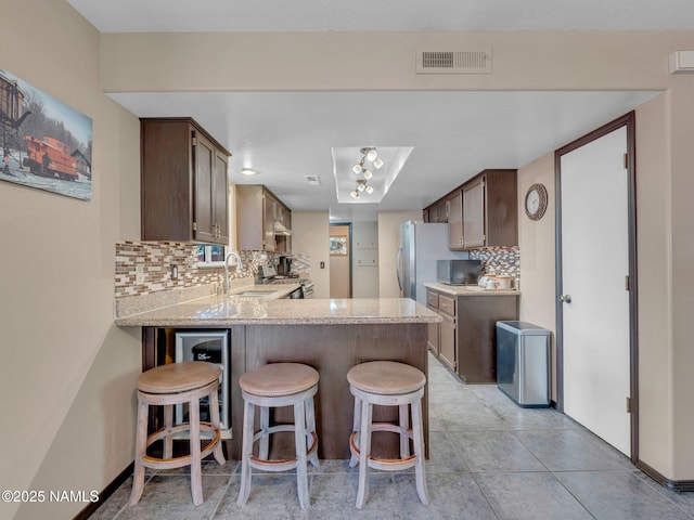 3114 N Connor St, Flagstaff, AZ 86004 - kitchen with a peninsula, backsplash, appliances with stainless steel finishes, and a breakfast bar area