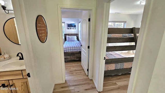 corridor with sink and light hardwood / wood-style floors