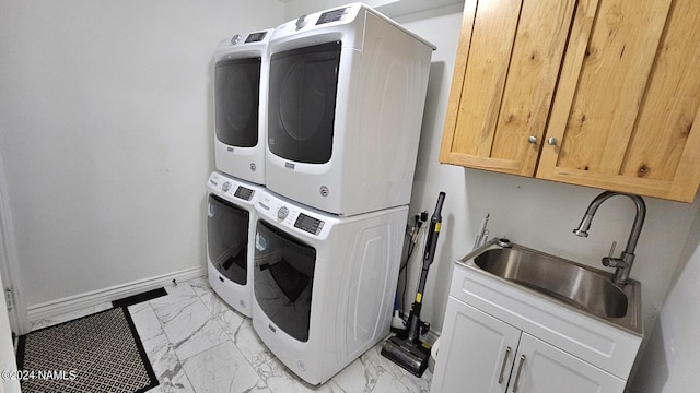 laundry area with sink, cabinets, and stacked washer / drying machine