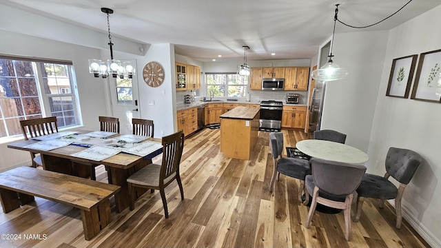 dining room with sink, light hardwood / wood-style floors, and a chandelier