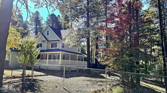 rear view of property featuring covered porch