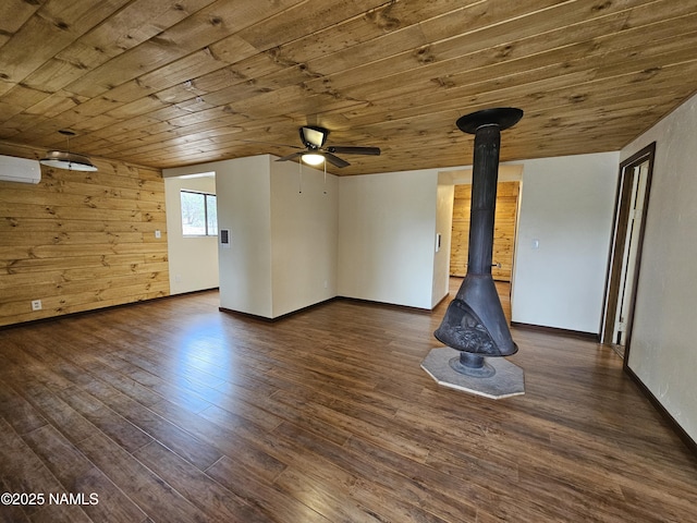588 W Mesa Dr, Williams, AZ 86046 - unfurnished room with wood ceiling, ceiling fan, a wall unit AC, hardwood / wood-style flooring, and a wood stove