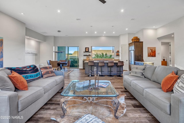 living area with recessed lighting and wood finished floors