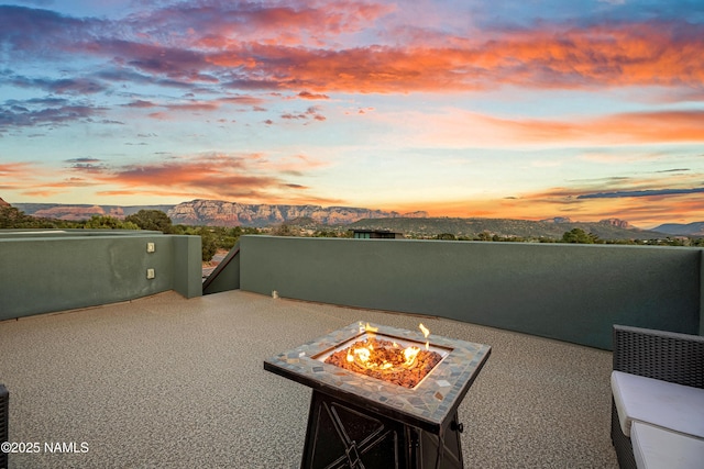 patio terrace at dusk with a mountain view and a fire pit