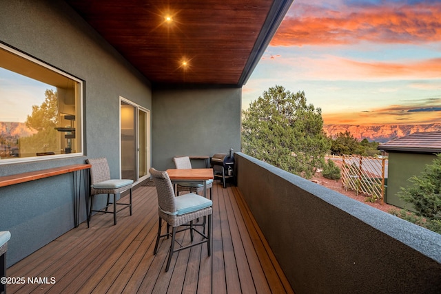 balcony at dusk featuring area for grilling