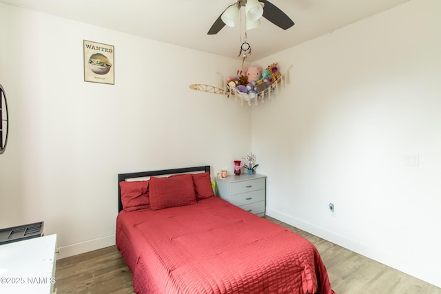 bedroom with a ceiling fan, baseboards, and light wood-type flooring