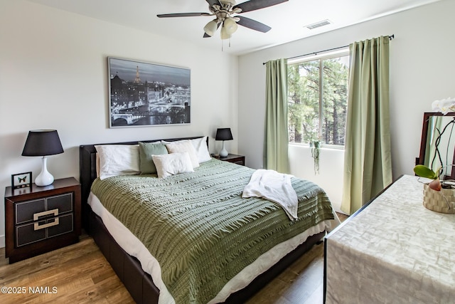 bedroom with visible vents, a ceiling fan, and wood finished floors