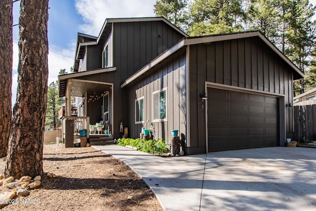 view of front of house with fence, covered porch, board and batten siding, and concrete driveway