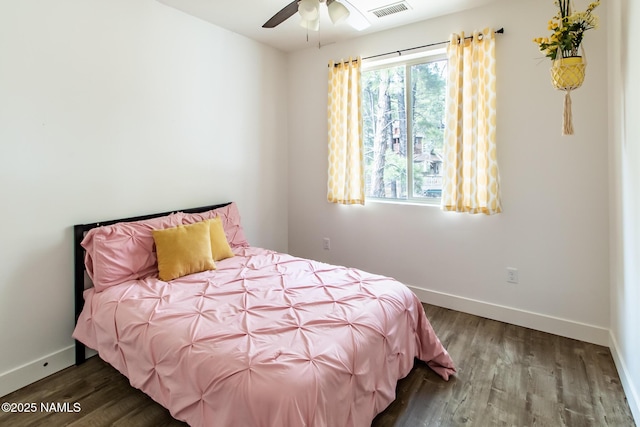 bedroom featuring ceiling fan, baseboards, visible vents, and wood finished floors