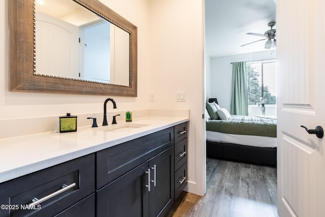 bathroom with ceiling fan, ensuite bath, wood finished floors, and vanity