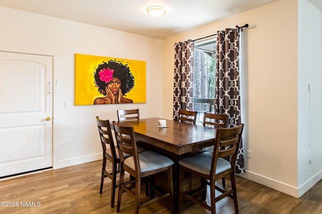 dining room featuring baseboards and wood finished floors