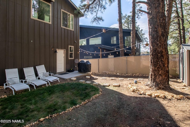 back of property with board and batten siding and fence private yard