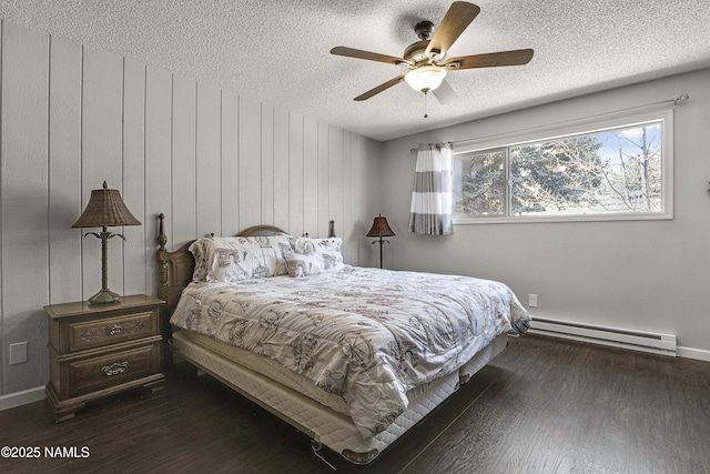 bedroom featuring dark wood-type flooring, a ceiling fan, a baseboard heating unit, a textured ceiling, and baseboards