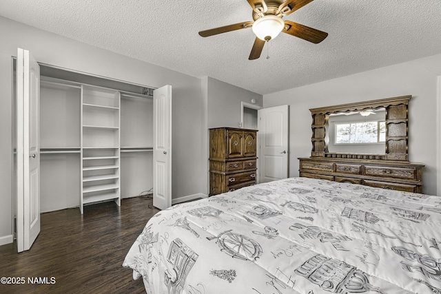 bedroom featuring a closet, dark wood-style floors, a textured ceiling, and a ceiling fan