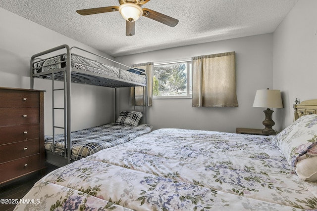 bedroom with a textured ceiling, ceiling fan, and dark wood-style flooring