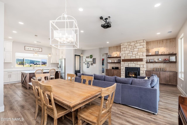 6552 Kelsey Springs Way, Flagstaff, AZ 86001 - dining room with a fireplace, light wood-style flooring, recessed lighting, and a chandelier