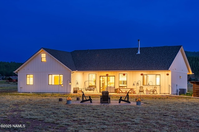 6552 Kelsey Springs Way, Flagstaff, AZ 86001 - back of house at twilight with a patio area, roof with shingles, and central AC unit