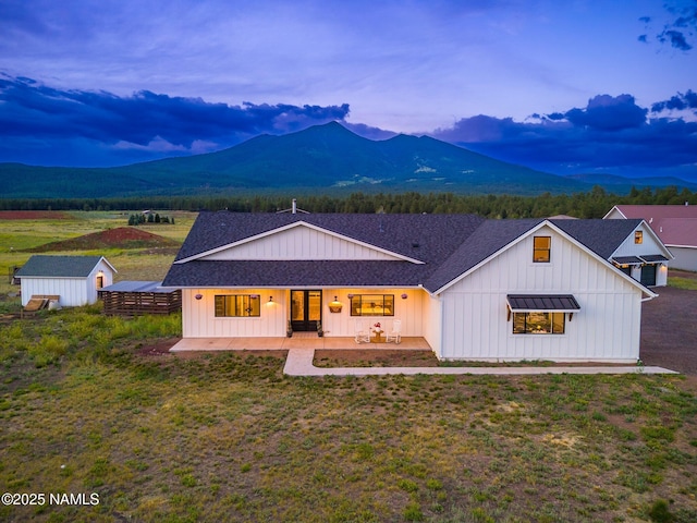 6552 Kelsey Springs Way, Flagstaff, AZ 86001 - view of front facade featuring board and batten siding, a mountain view, an outdoor structure, and a patio
