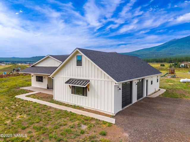 6552 Kelsey Springs Way, Flagstaff, AZ 86001 - view of property exterior featuring a shingled roof, a mountain view, board and batten siding, and a detached garage