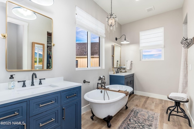 6552 Kelsey Springs Way, Flagstaff, AZ 86001 - full bathroom featuring wood finished floors, a soaking tub, baseboards, and two vanities