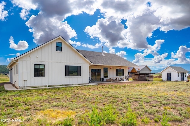 6552 Kelsey Springs Way, Flagstaff, AZ 86001 - rear view of house with board and batten siding, a lawn, and a patio
