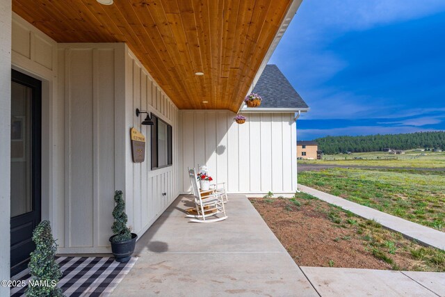 6552 Kelsey Springs Way, Flagstaff, AZ 86001 - doorway to property with board and batten siding, a shingled roof, and a patio area