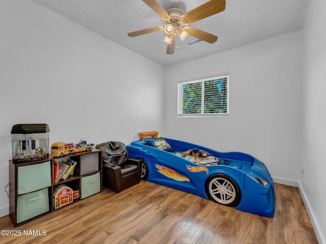 7776 Moonbeam Dr, Flagstaff, AZ 86004 - bedroom featuring wood finished floors, a textured ceiling, and ceiling fan