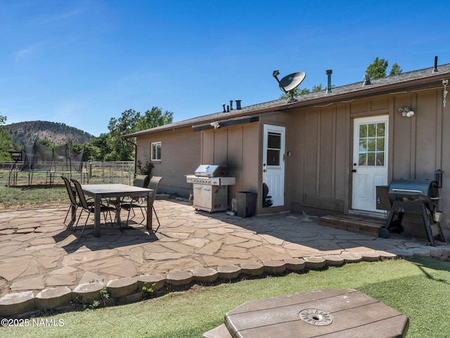 7776 Moonbeam Dr, Flagstaff, AZ 86004 - view of patio / terrace featuring a grill, a mountain view, a trampoline, and outdoor dining space