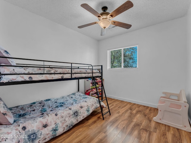 7776 Moonbeam Dr, Flagstaff, AZ 86004 - bedroom featuring wood finished floors, a textured ceiling, and a ceiling fan