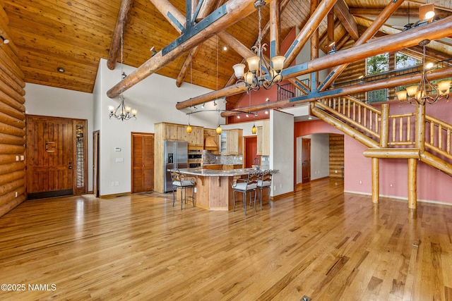 4536 Brackin Ranch Rd, Flagstaff, AZ 86001 - living room with a chandelier, high vaulted ceiling, light wood-style flooring, arched walkways, and stairs