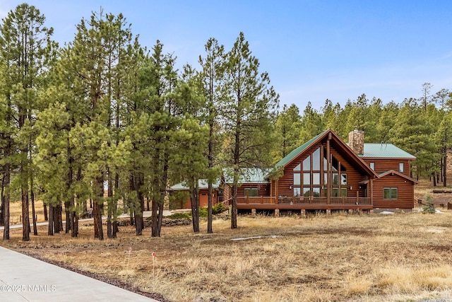 4536 Brackin Ranch Rd, Flagstaff, AZ 86001 - view of front facade with a chimney, a deck, metal roof, and log veneer siding