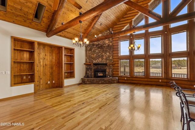 4536 Brackin Ranch Rd, Flagstaff, AZ 86001 - unfurnished living room with a chandelier, high vaulted ceiling, wooden ceiling with exposed beams, wood-type flooring, and a stone fireplace