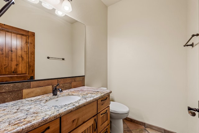 4536 Brackin Ranch Rd, Flagstaff, AZ 86001 - half bath with vanity, toilet, baseboards, backsplash, and tile patterned floors