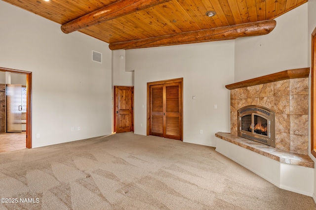 4536 Brackin Ranch Rd, Flagstaff, AZ 86001 - unfurnished living room featuring wood ceiling with exposed beams, carpet floors, a towering ceiling, and a fireplace
