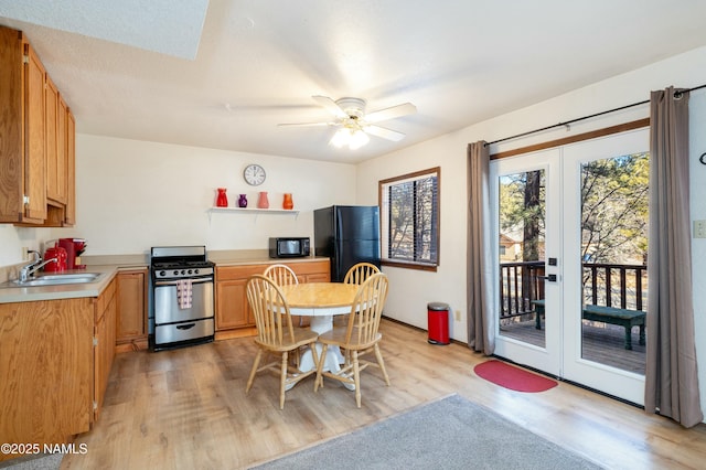 dining room featuring french doors, ceiling fan, sink, and light hardwood / wood-style flooring